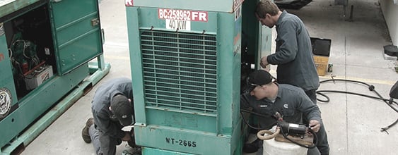 group of mechanics performing routine maintenance on a generator